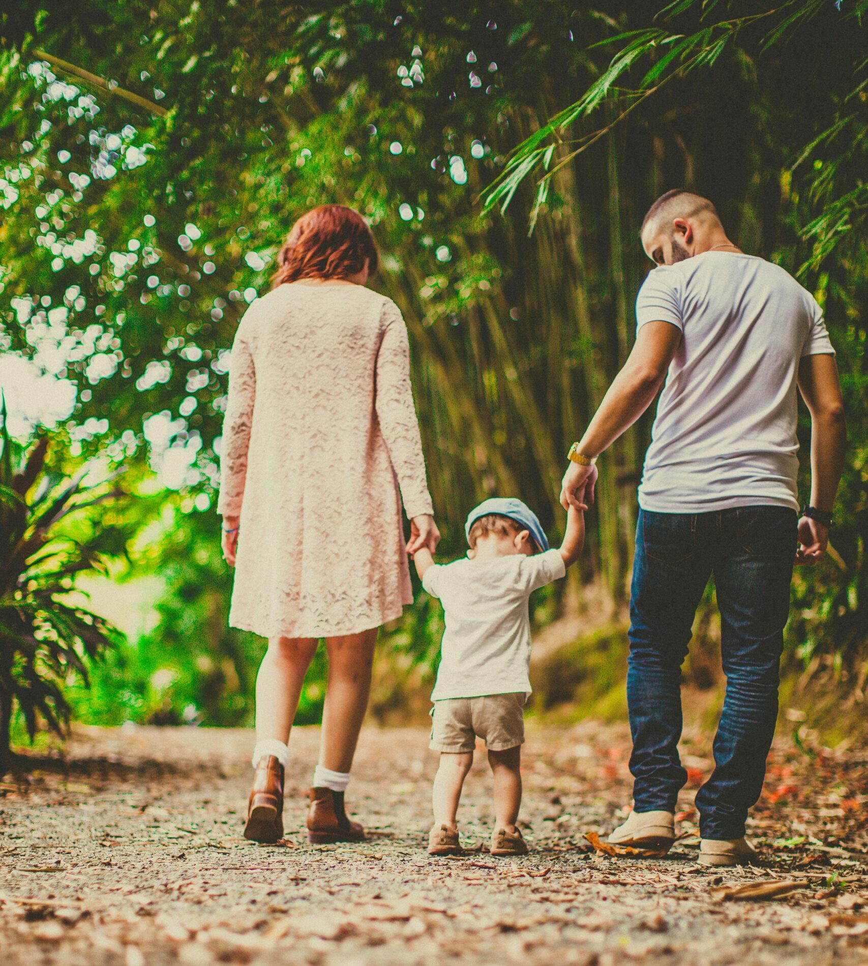 A family enjoys a leisurely walk in a green park, embodying joy and togetherness.